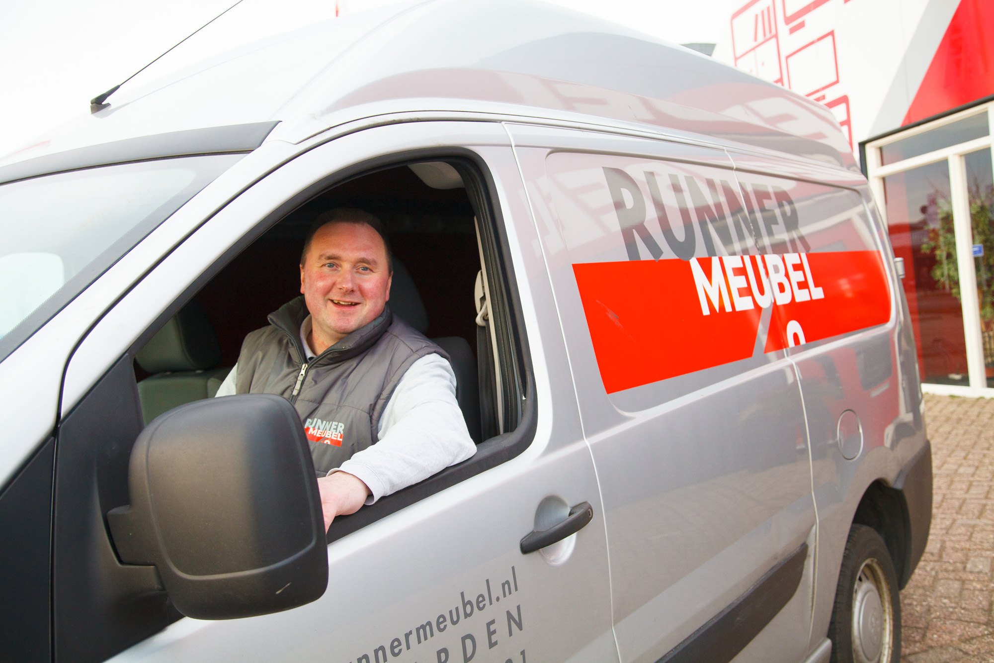 De eigenaar van Runner Meubel achter het stuur van de bezorgbus